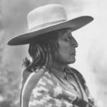 a black and white photo of a woman wearing a hat