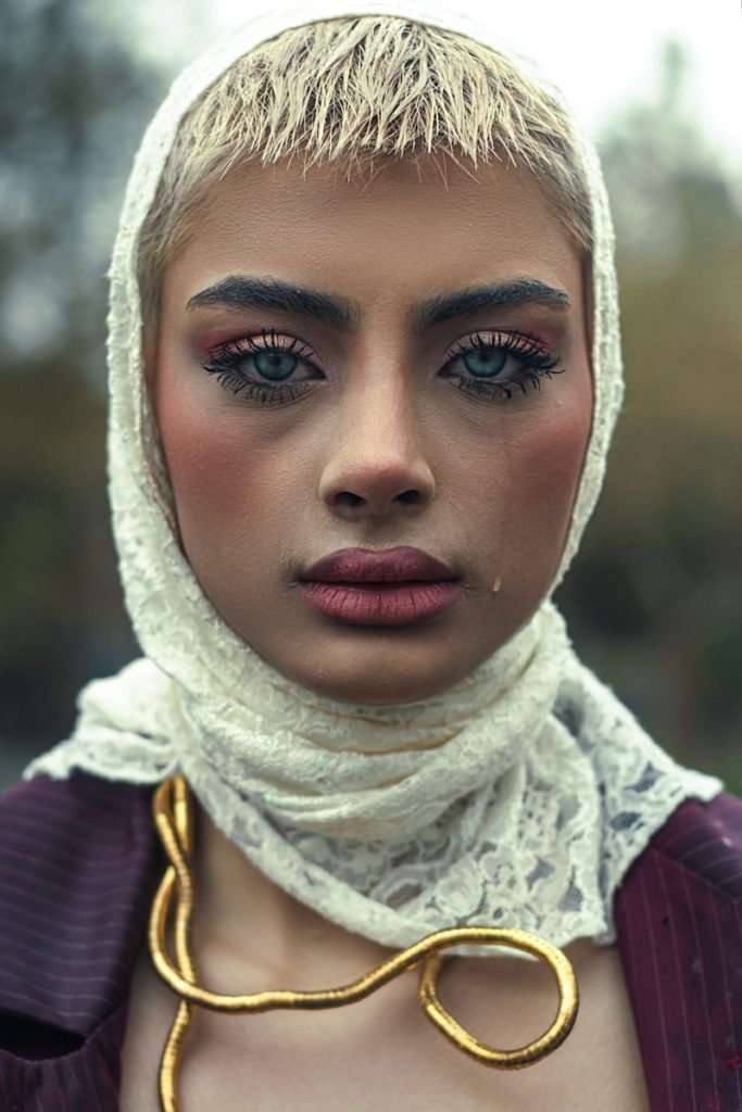A woman is wearing a headscarf, looking sad.